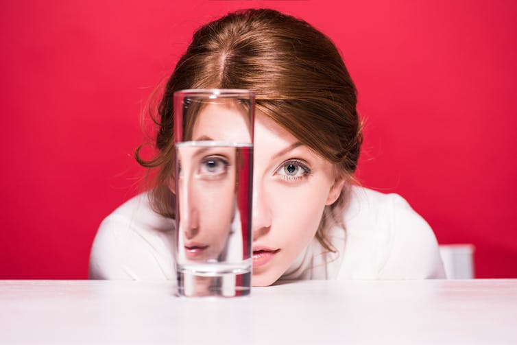 Woman staring at glass of water on counter