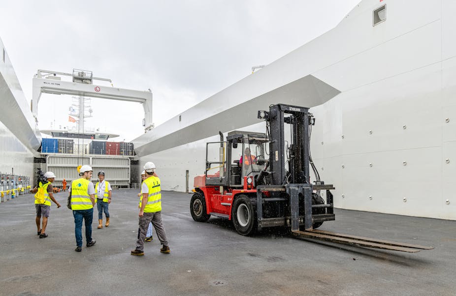 Des employés du groupe Ariane sur le cargo 'Canopee' au port de Pariacabo, à Kourou en Guyane, le 16 janvier 2023.