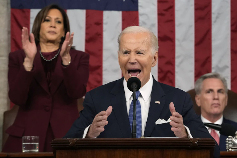 President Joe Biden delivers speech while Kamala Harris stands and claps and Kevin McCarthy sits behind him