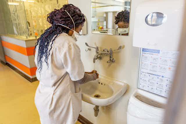 Doctor Washing Her Hands in a Hospital Ward