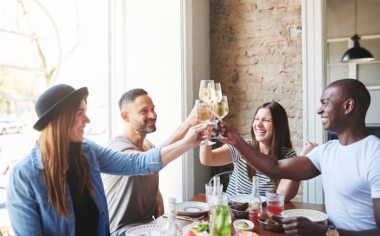 A group of people at a restaurant sharing a toast.