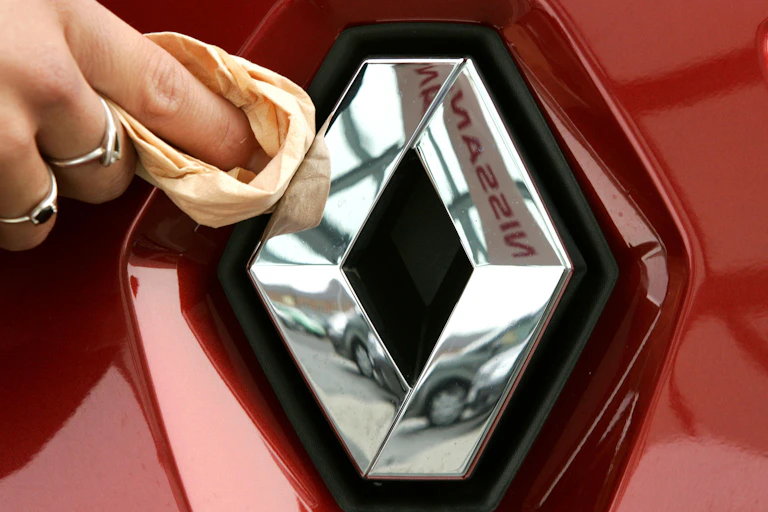 A hand polishes the logo of the French car manufacturer Renault at a car dealer in Duesseldorf, Germany, 5 January 2005.