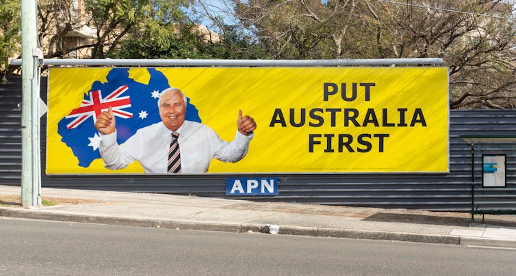 man smiling on sign with words 'put Australia first'