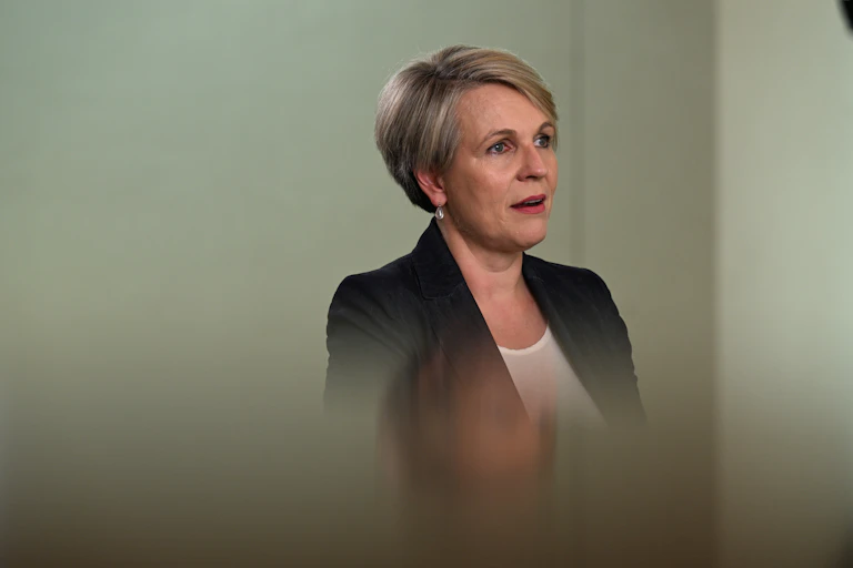 woman in black suit jacket looks off camera
