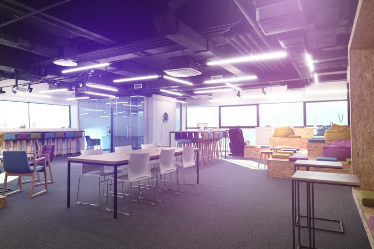 An open plan area with different desks and chairs.