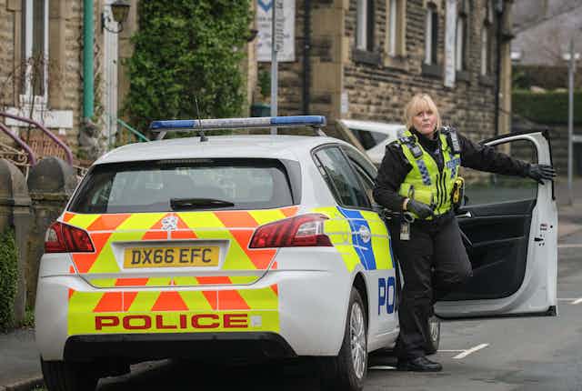 Sarah Lancashire wears police uniform, steps out of police car