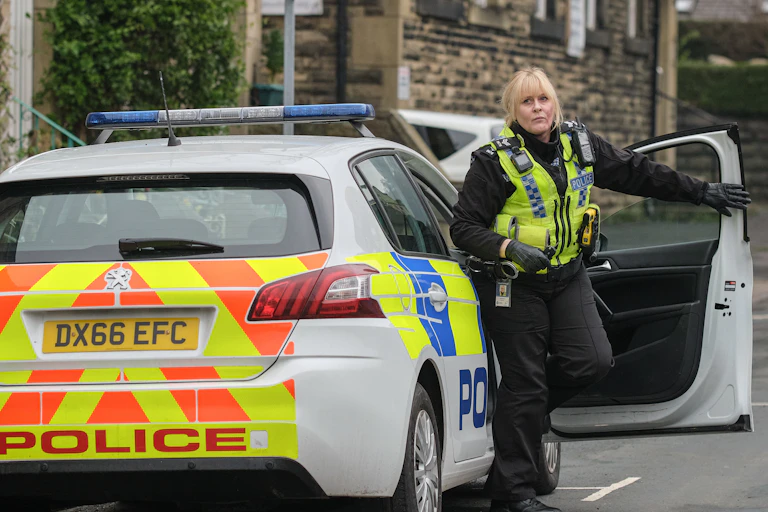 Sarah Lancashire wears police uniform, steps out of police car