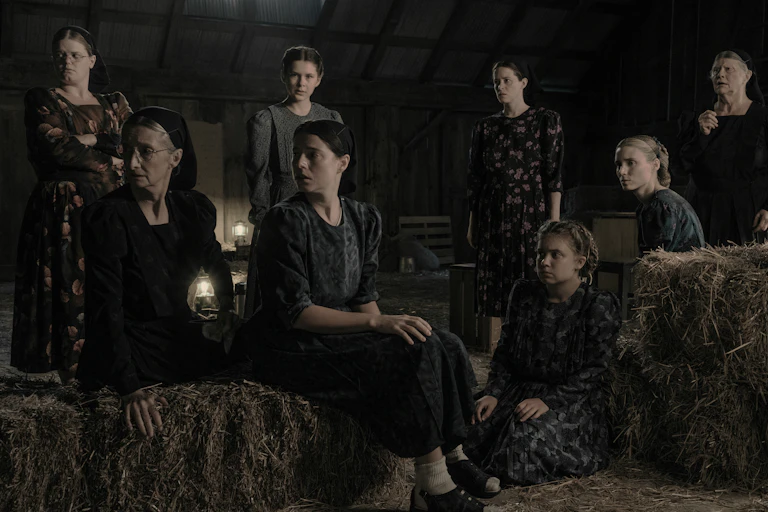 A group of mennonite women in a barn.