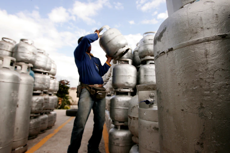 A person lifts LPG gas cylinders
