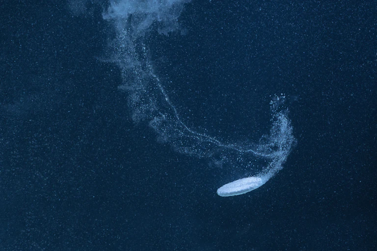 Un comprimé d'aspirine se dissout dans une eau sombre