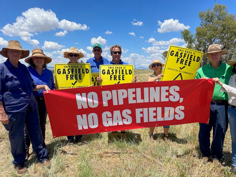 people hold sign reading 'no pipelines, no gas fields'