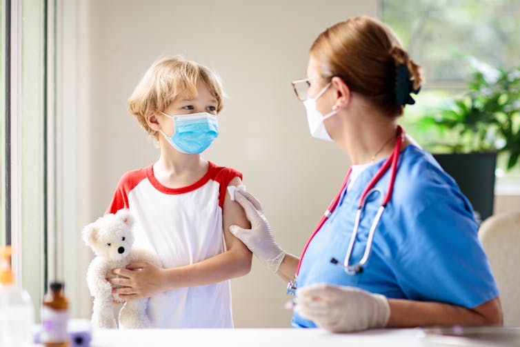 A child with a healthcare worker after receiving a vaccine.