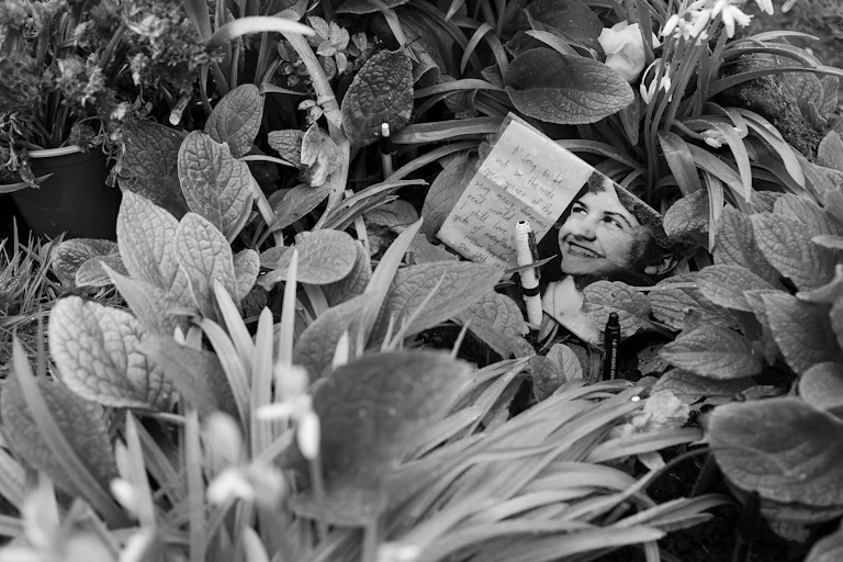 A card with a photo of Sylvia Plath on at her grave.
