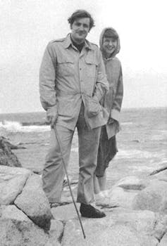 Sylvia Plath with husband Ted Hughes standing on rocks at the seaside.