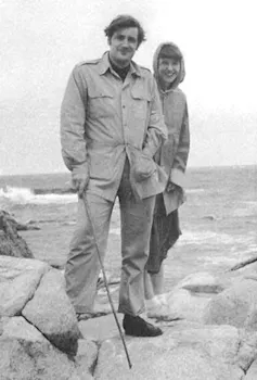 Sylvia Plath with husband Ted Hughes standing on rocks at the seaside.