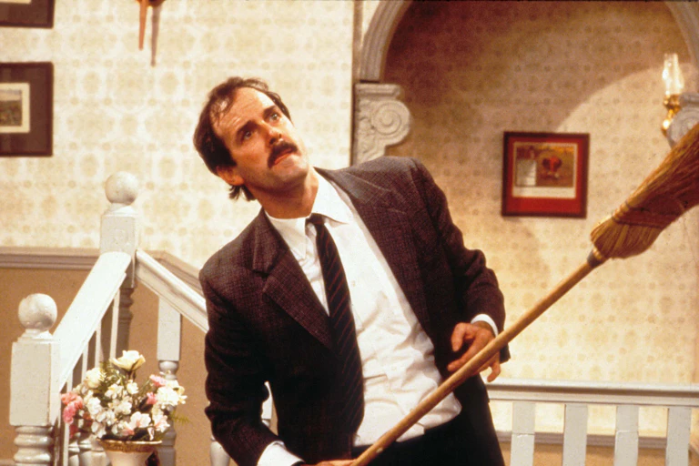 A man with a broom and his tongue out.