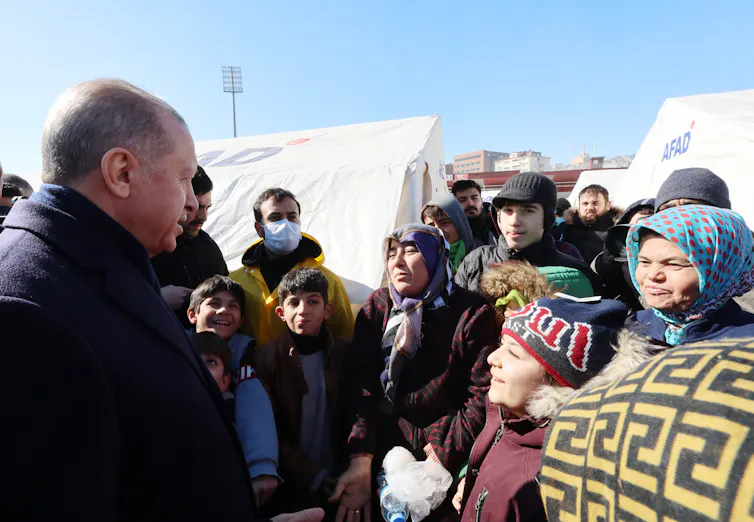 urkey's president, Recep Tayyip Erdoğan, talks to a woman wrapped in a blanket and other victims of the earthquake.