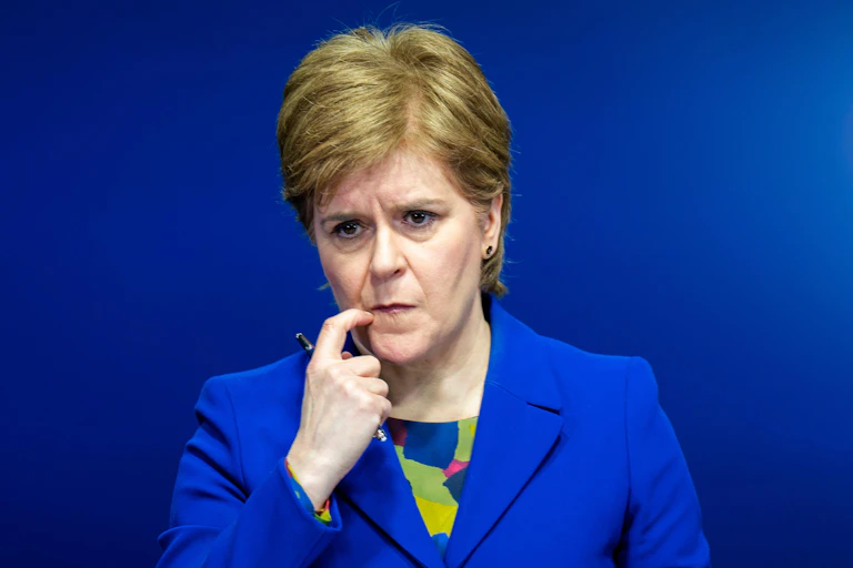 Nicola Sturgeon on a podium scratching her lip