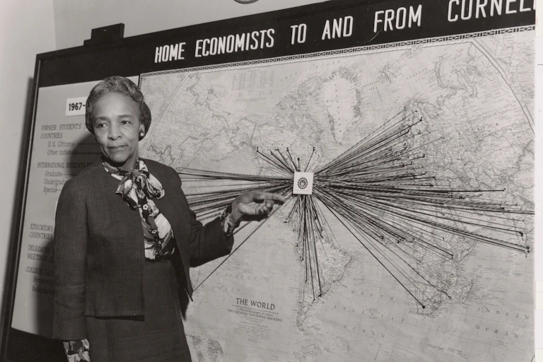 A woman stands in front of a map