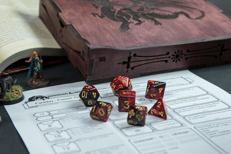 Seven red dice sit on top of a tabletop role-playing game character sheet