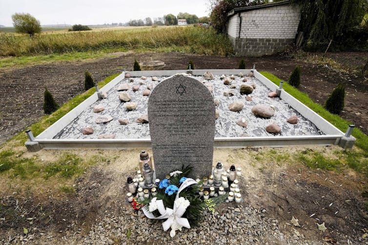 Flowers next to a grave stone with a star of david.