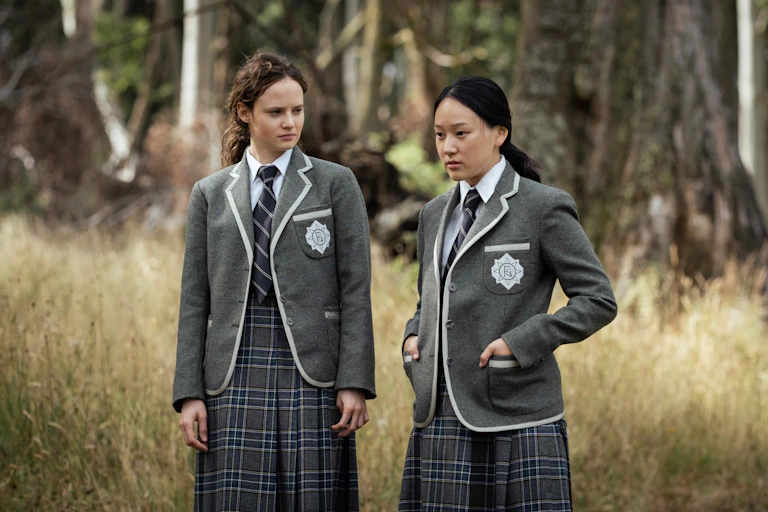 Two girls in uniforms talking