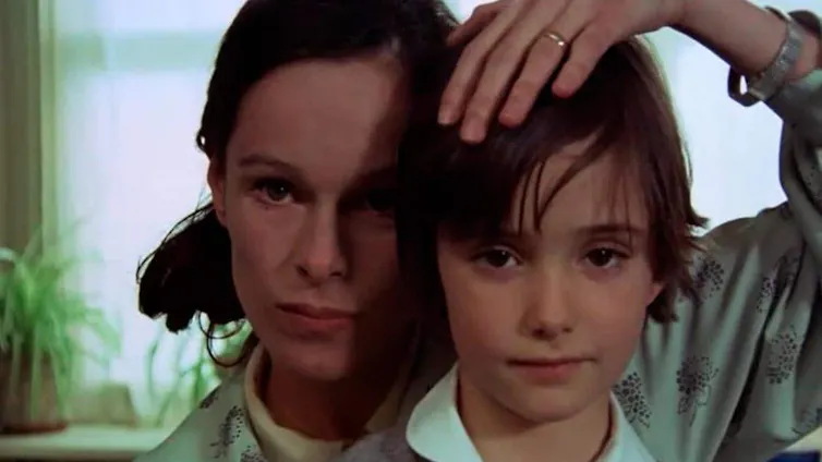 A woman and a girl look at the camera.