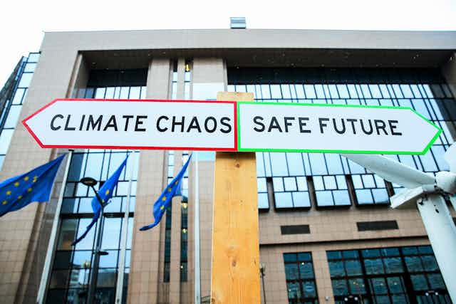 A signpost depicting energy crossroads, one way is climate chaos the other is a safe future.