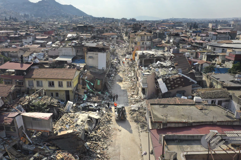 Many homes nestled near mountains surrounded by rubble.