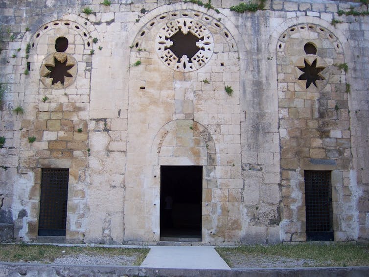 The stone façade to St. Peter's Cave Church with three entrances.