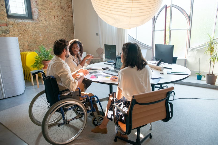 People seen sitting around a table collaborating.