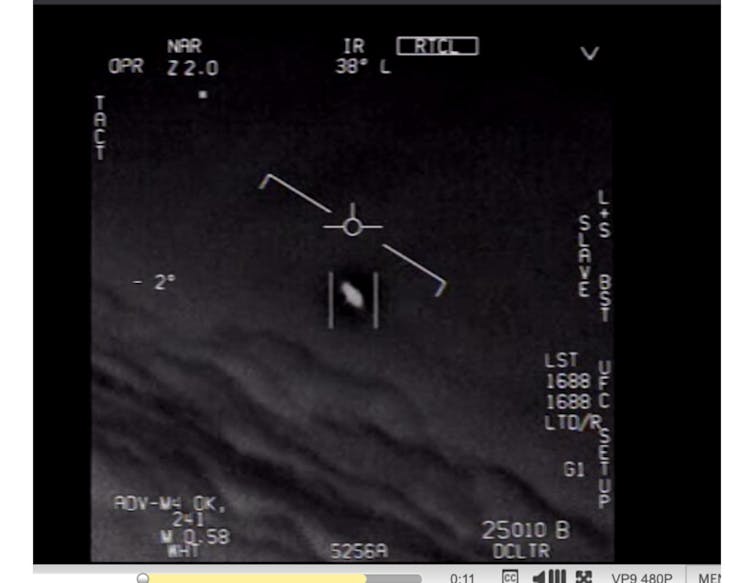 A screenshot from a Navy video taken by a pilot showing a white, mysterious craft in the sky. UFO