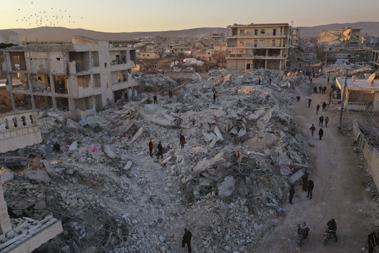 people walking around collapsed buildings in Aleppo Syria