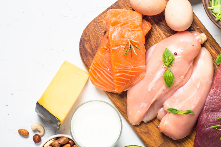 Salmon, chicken, beef, nuts, oil, cheese, milk and avocado on white background.