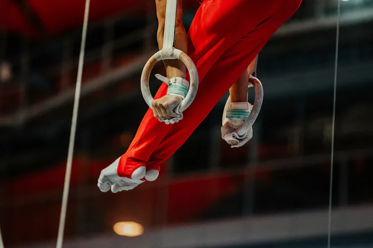 A gymnast hanging on rings.