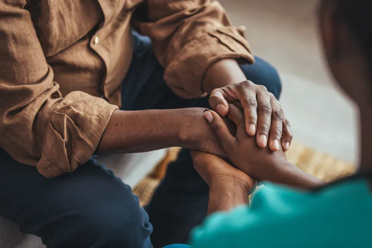 Two people clasp their hands together.