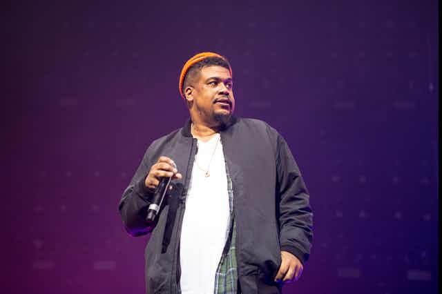A man in beanie with a microphone. 