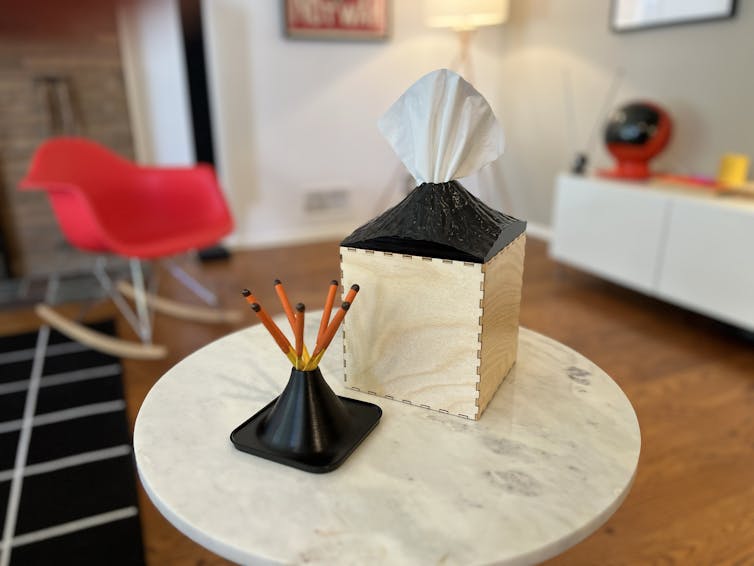 Prototypes of a volcano-themed tissue box and match holder.