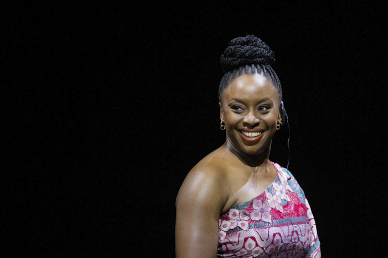 A woman seen smiling on a stage.