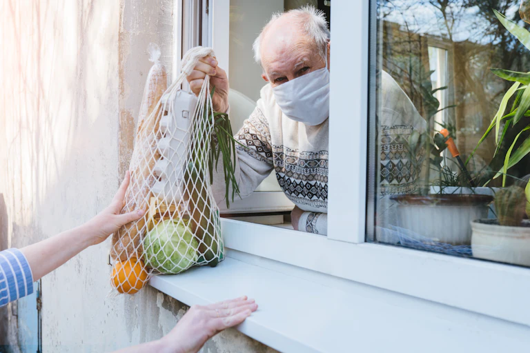 A person in isolation receiving a bag of food
