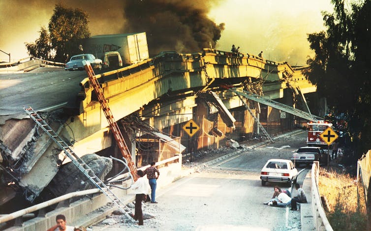 collapsing bridge and roadway with black smoke and fire engine