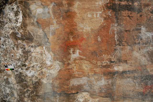 Indistinct image of horses and riders on rock surface