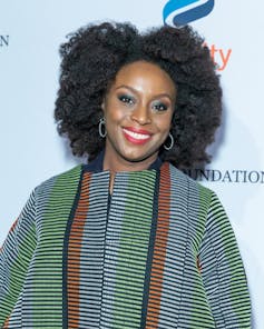 A woman in a striped top against a pale blue background.