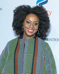 A woman in a striped top against a pale blue background.