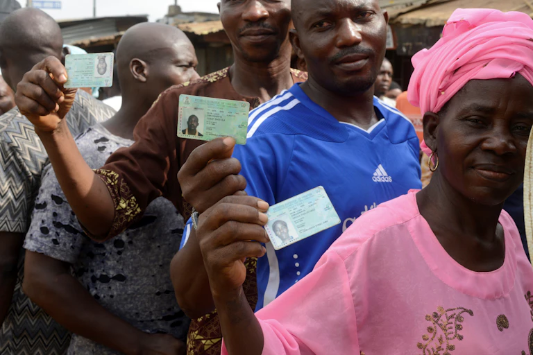 People displaying a card while on a queue
