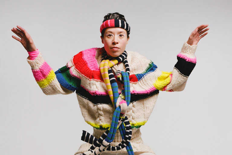 A woman in a lot of knitted accessories.