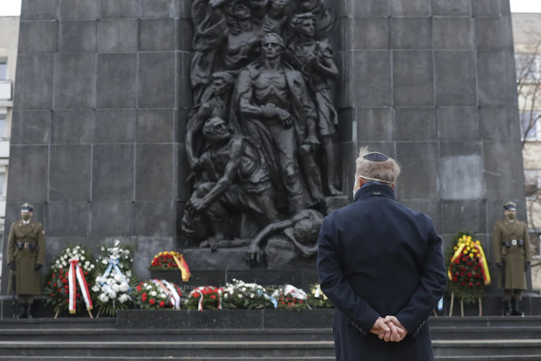 Un homme de dos se tient devant un monument