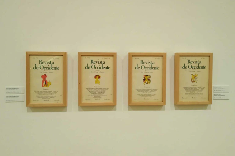 Portadas de diferentes números de la Revista de Occidente enmarcados y colgados en la pared.