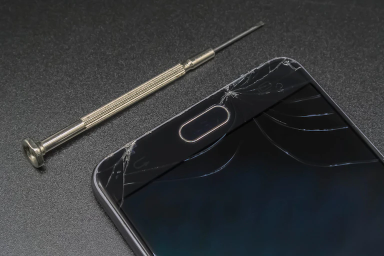 Smartphone cassé avec un tournevis.