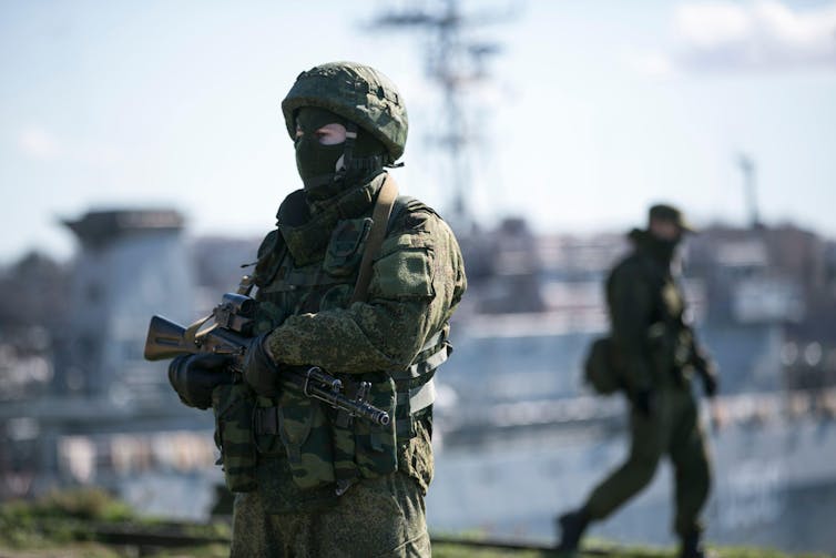 A Russian soldier with a port behind him.